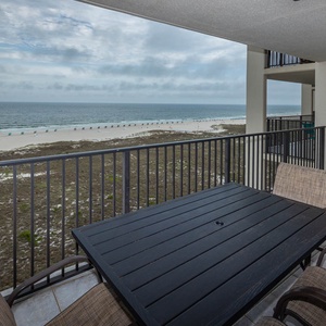 Balcony overlooks the beach, with views of the white sand and colorful beach umbrellas lining the shore