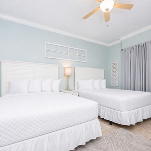 Rest in the queen beds of this guest bedroom, feeling refreshed and ready for your day's adventures at the beach
