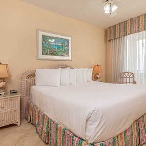 Unwind in this master bedroom featuring a king bed, charming decor, and beachfront balcony access