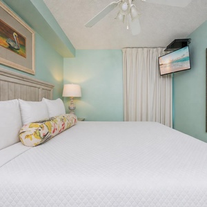 Fluffy pillows invite you to relax in the king suite for a calm movie night after a fun day at the beach