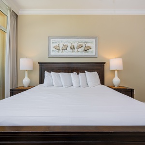Unwind in the master bedroom with a plush king bed, soft lighting, and coastal art that enhances relaxation