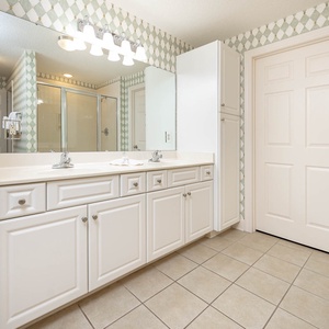 Experience this spacious master bath featuring a double vanity, ample storage, and a refreshing glass walk-in shower
