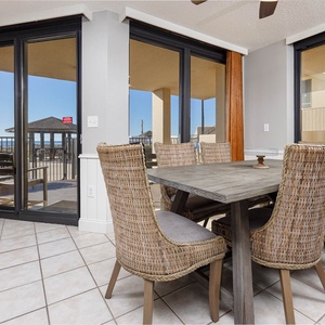 Dining area features a rustic table surrounded by woven chairs, with sliding doors leading to the ground floor patio