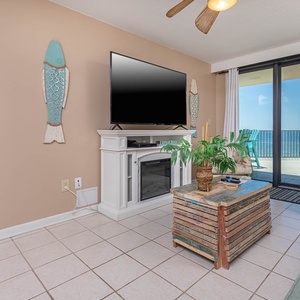 This inviting living area features a large TV, cozy seating, queen sofa-sleeper, and a breathtaking view from the balcony