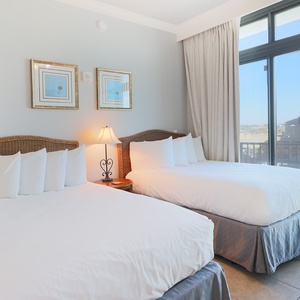 Relax on one of the cozy double beds in this guest suite and enjoy a peaceful slumber with coastal balcony views