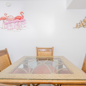 Bright dining area featuring a glass-top table and tropical flamingo decor, perfect for enjoying meals with family