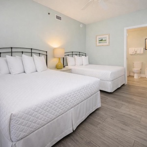 Brightly colored walls complement two double beds, creating a welcoming atmosphere in this cozy guest bedroom