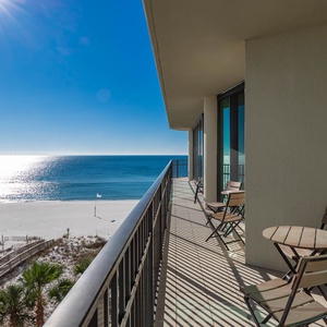 Enjoy the fresh air on the balcony with seating, perfect for relaxing while taking in the beautiful coastal views