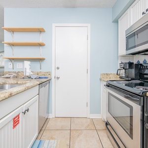Kitchen featuring granite countertops, stainless appliances, coffee station, and open shelving for a welcoming experience