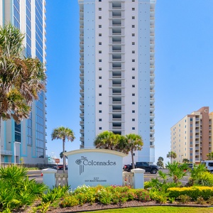 Experience a welcoming entrance at The Colonnades, surrounded by lush greenery and just steps from the beautiful beach