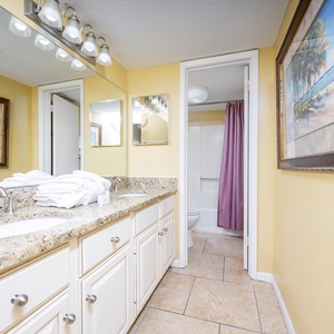 Refreshing master bathroom featuring a granite countertop, plush towels, and a relaxing tub/shower combo
