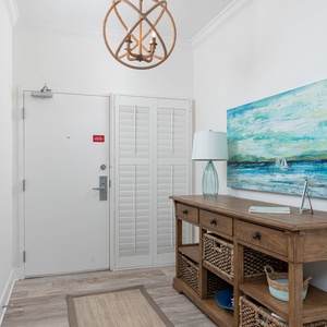 Step into a welcoming entryway featuring coastal decor, a stylish console table, and ample storage for your belongings