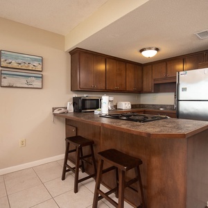 This kitchen features rich wood cabinetry, stainless appliances, and a convenient breakfast bar for casual dining