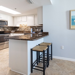 Prepare meals in this stylish kitchen with granite countertops, stainless appliances, tile backsplash, and cheerful decor