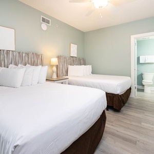 Rest in this inviting guest room with two comfortable double beds, stylish decor, and easy access to the guest bathroom