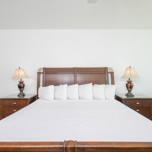 Relax in this inviting master bedroom featuring a king bed, stylish lamps, and a cozy seating area for ultimate comfort