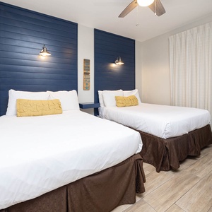 Relax in this inviting guest room featuring two double beds, stylish decor, and soft natural light