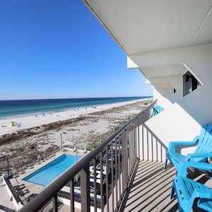 Enjoy stunning beachfront views from this balcony, complete with comfortable seating and a glimpse of the inviting pool below