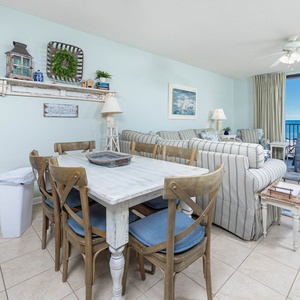 Relax in the inviting living area with comfortable seating and a dining table, all while enjoying the beach views
