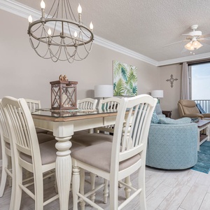 Gather around the dining table with comfortable seating, enjoying the coastal decor and inviting atmosphere