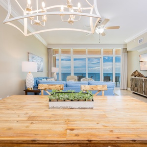 Gather around the rustic dining table, enjoying views of the inviting living area and the stunning beach beyond