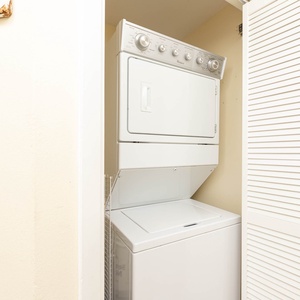 Conveniently access the stacked washer and dryer, perfect for keeping your beach attire fresh during your stay