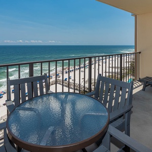Enjoy breathtaking views from the private balcony, featuring comfortable seating and a table overlooking the serene beach