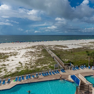 Enjoy the inviting pool area with lounge chairs, offering easy access to the beach and beautiful coastal views