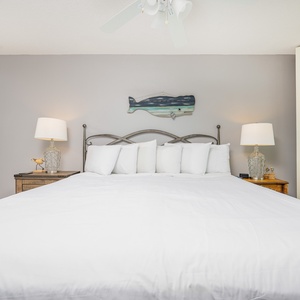 Enjoy restful nights in the spacious master bedroom featuring a king bed, bedside lamps, and coastal decor