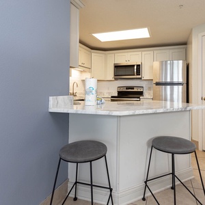 Enjoy casual meals at the sleek breakfast bar, featuring stylish stools and a view into the inviting kitchen space