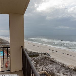 Enjoy breathtaking views of the serene beach and gentle waves from the inviting balcony of this coastal retreat