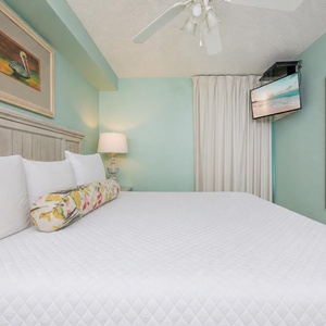 Fluffy pillows invite you to relax in the king suite for a calm movie night after a fun day at the beach