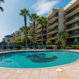 Relax by the inviting pool surrounded by palm trees and enjoy the beautiful bay view from your vacation rental balcony