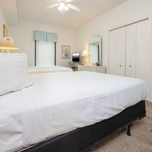 Unwind in this guest bedroom featuring two queen beds, a TV, and charming decor for a restful night's sleep