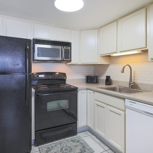 This kitchen features sleek black appliances, ample counter space, and a welcoming atmosphere for home-cooked meals