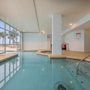 Enjoy this refreshing indoor pool area with views of the outdoor pool and palm trees, perfect for unwinding after a day of fun