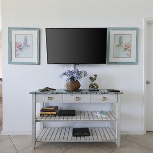 Stylish console table with a TV, decorative vases, and framed artwork creates a welcoming atmosphere in this living area