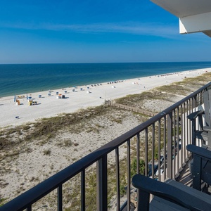 Enjoy breathtaking beachfront views from this balcony, featuring comfortable seating for relaxation and unwinding