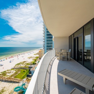 Relax on the spacious balcony with views of the beach and shimmering water below