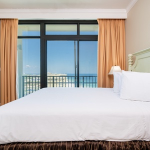 Wake to a breathtaking sunrise in this queen guest suite with expansive views from the balcony windows