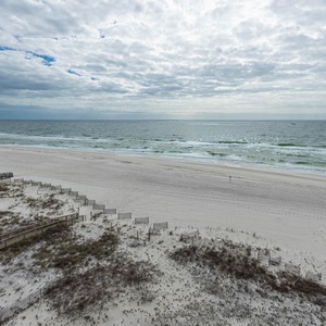 Expansive view of soft sand and gentle waves, perfect for peaceful moments and relaxing strolls along the shore