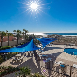 Relax under the blue shade sails by the pool, soaking in the sun and enjoying views of the tranquil waters nearby