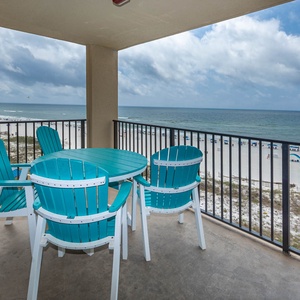 A turquoise table and chairs on the balcony offer a relaxing spot to enjoy the beach front view and gentle gulf breeze