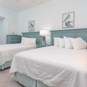 Relax on one of the cozy queen beds in this guest suite and admire the relaxing coastal decor