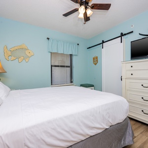 Serene guest bedroom featuring a queen bed, charming decor, and a flat-screen TV for your entertainment