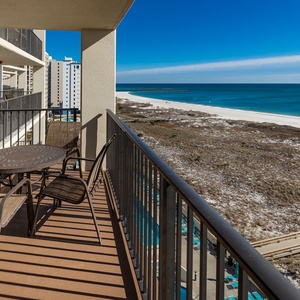 Balcony seating offers a serene view of the beach and turquoise waters, perfect for enjoying morning coffee with the sunrise