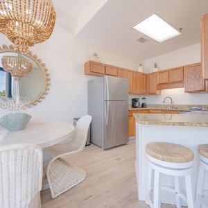 Prepare meals in this kitchen featuring granite countertops, stainless and white appliances, and inviting seating
