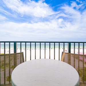 Enjoy the fresh air on the balcony with a table and chairs, overlooking the shimmering waters and beach below