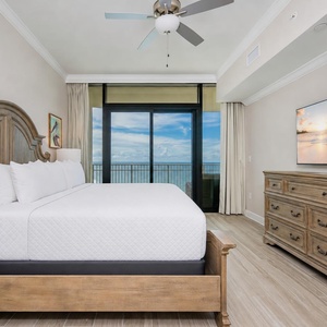 Relax in the master bedroom featuring a king bed and a balcony that showcases beautiful beachfront views