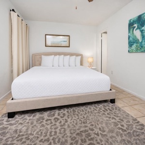 This bedroom features a plush bed, soft rug, and calming artwork, perfect for a restful getaway
